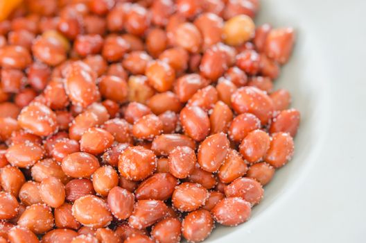 close up pile of  honey roasted peanuts  with skin