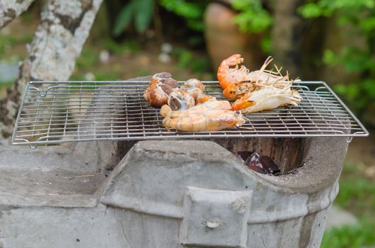 Spotted babylon and shrimps on grill cooking
