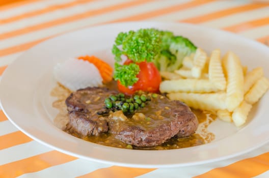 close up beef steak with green peppercorn sauce