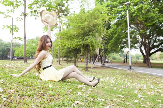 Woman sitting on the grass. In the park and the blossoms filled the yard.