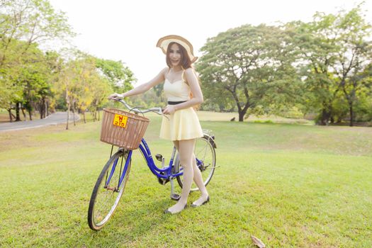 Asian woman and bikes. On the grass in the park.