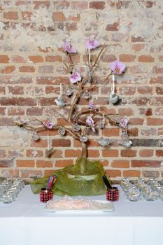 Decorative tree at wedding reception with silver doves and purple flowers in an unusual setting
