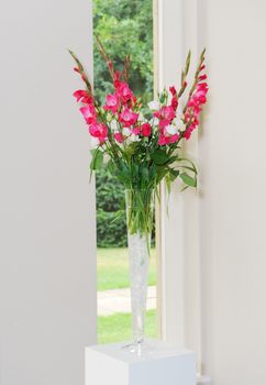 Red and white flowers decorate wedding ceremony in glass vase