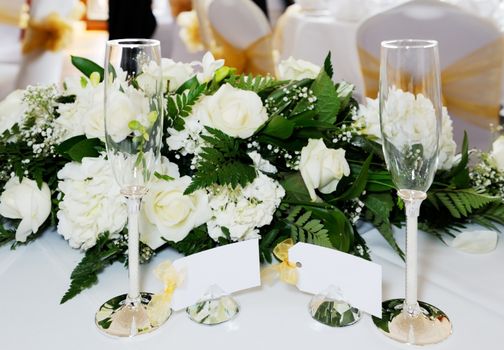 Closeup of bride and grooms champagne glasses on top table at wedding reception