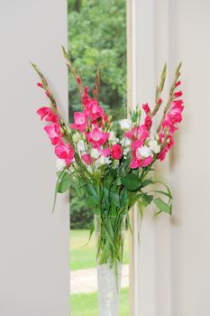 Red and white floral arrangement decorate wedding ceremony in glass vase