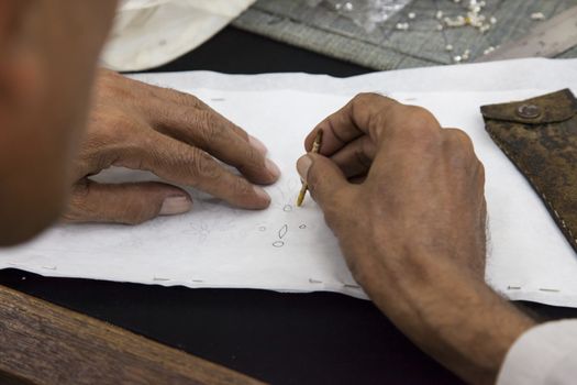 Worker drawing stencil motif on cloth