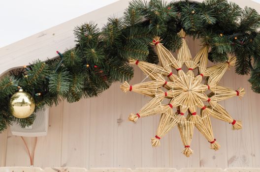 handmade christmas tree decoration star twisted from dry straw hanging on the house corner
