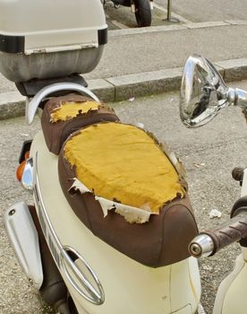 Close up on damaged seat of scooter in the street