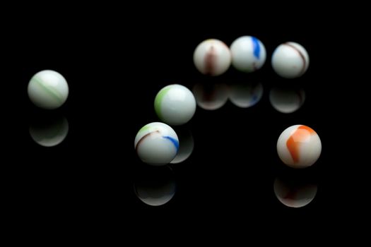 photo of color marbles on black with reflection