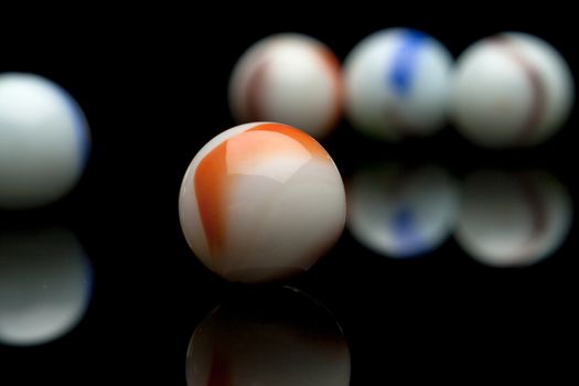 photo of color marbles on black with reflection