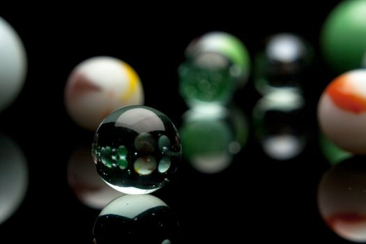 photo of color marbles on black with reflection