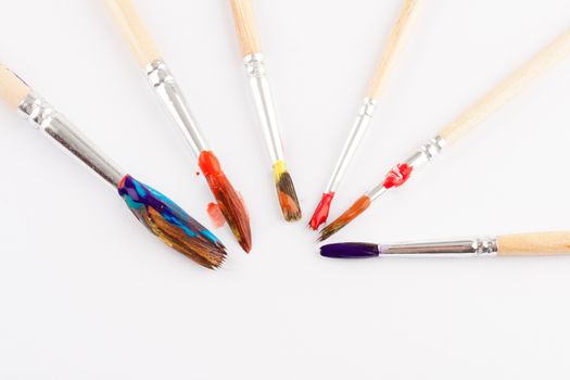 different size artist paint brushes on white