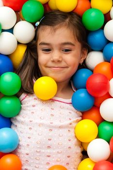 young girl playing with color toy balls