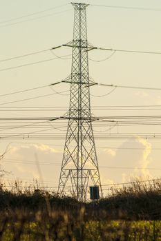 high voltage pylon with cables and landscape