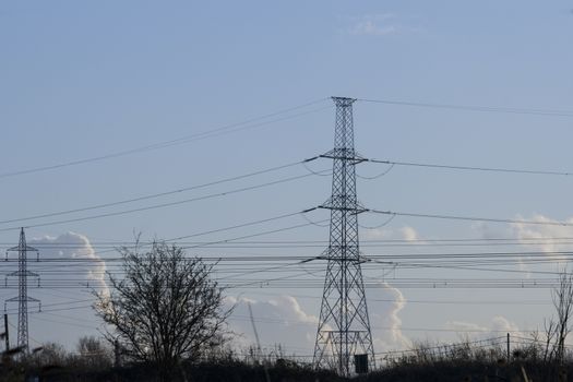 high voltage pylon with cables and landscape