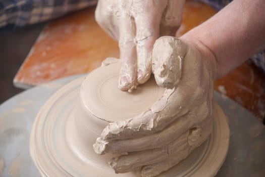 Hands of a potter, creating an earthen jar on the circle