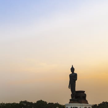 Big Buddha in the evening. The dark sky with bright sunshine in the evening.