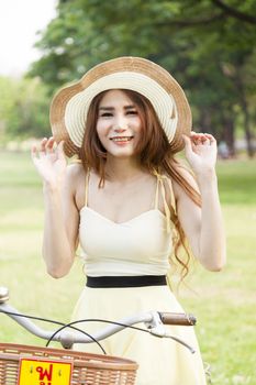 Woman holding a hat. Happy and relaxed in the relaxation area of the park.