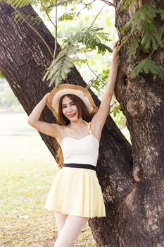 Portrait Asian woman in the park. Under the tree and smiling