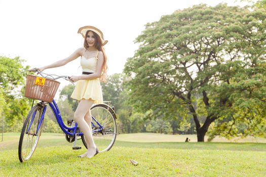 Asian woman and bikes. On the grass in the park.