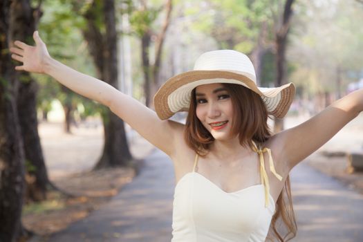 Woman riding a bicycle. Woman with hat riding a bicycle in the park.