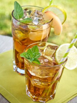 Refreshing peach, lime and mint ice tea served outdoors