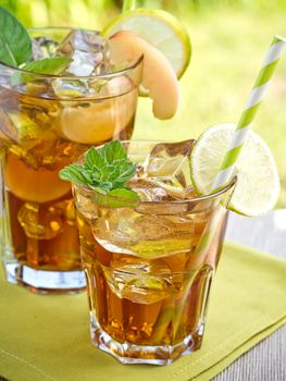 Refreshing peach, lime and mint ice tea served outdoors