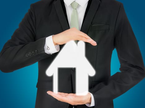 Businessman standing posture hand holding house icon isolated on over blue background