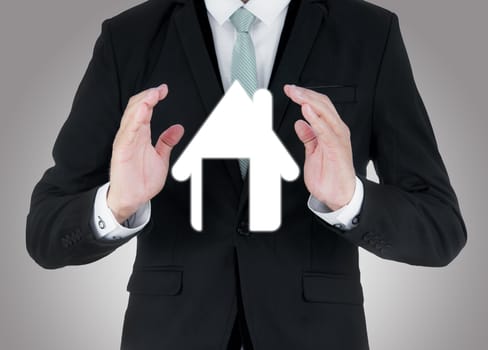 Businessman standing posture hand holding house icon isolated on over blue background