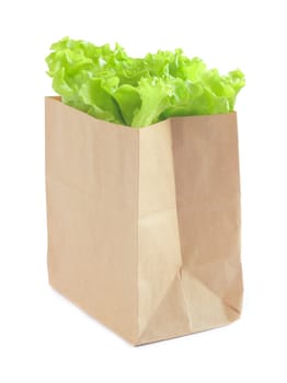 Grocery bag with green lettuce salad isolated on white background