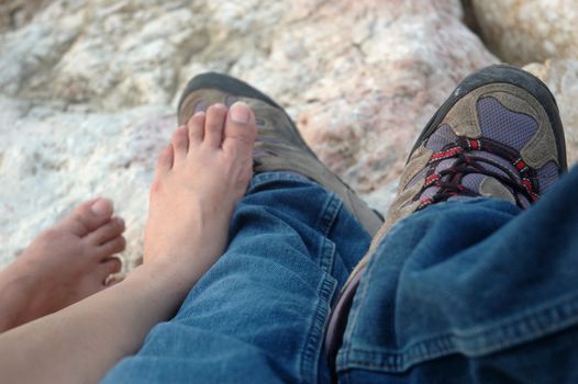 man and woman feet with natural beach rock as background