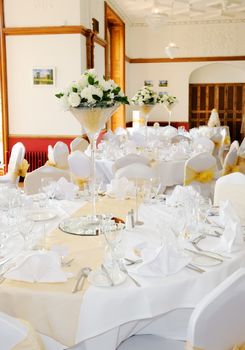 Floral arrangements decorate wedding reception with white flowers in glass on tables