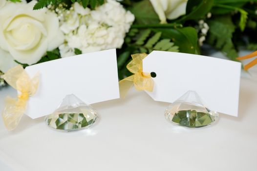 Closeup detail of wedding reception place cards on top table with white floral arrangement