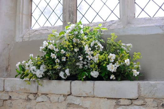 Flowers decorate a church for a wedding.