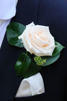 Closeup of grooms roses pinned to his suit jacket.