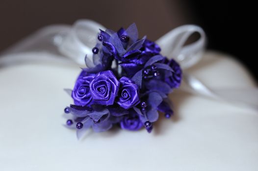 Purple flower decortion on top of wedding cake.