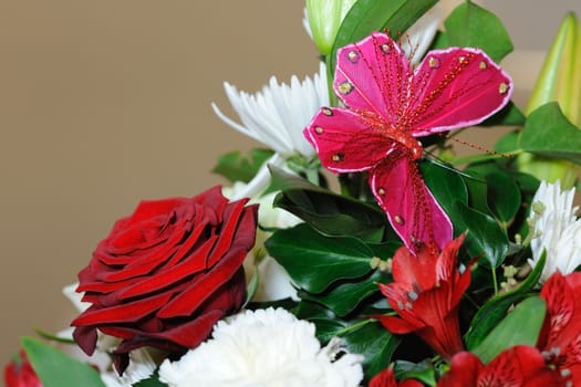 Red roses and butterfly decorate a table at a wedding reception.