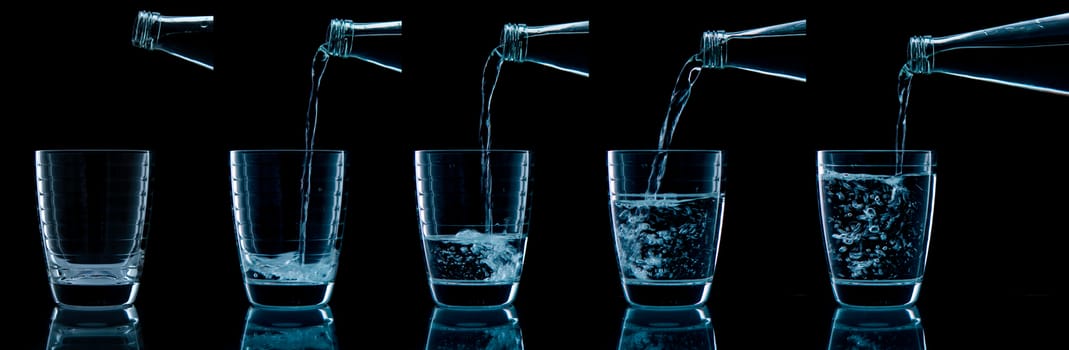 Pouring water on glass on over black background