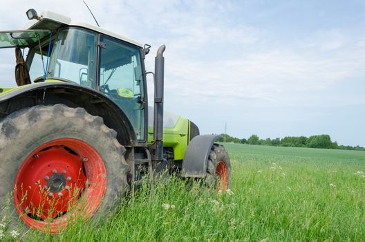 season of field work heavy equipment tractor stands in meadow