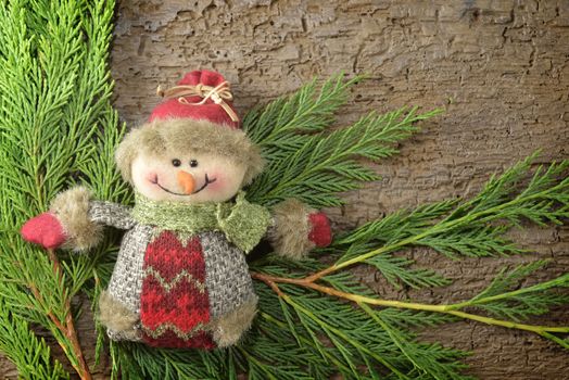 Christmas Background Snowman and spruce branches on wooden background