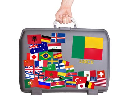 Used plastic suitcase with lots of small stickers, large sticker of Benin
