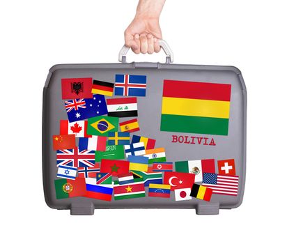 Used plastic suitcase with lots of small stickers, large sticker of Bolivia