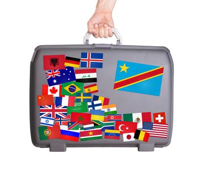 Used plastic suitcase with lots of small stickers, large sticker of Congo