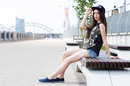 Street, outdoor. Attractive teen in a cap