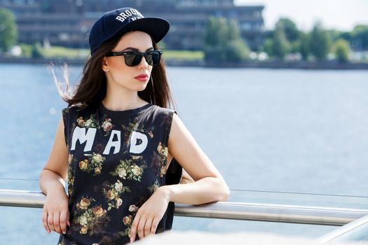 Street, outdoor. Attractive teen in a cap