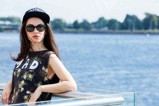 Street, outdoor. Attractive teen in a cap