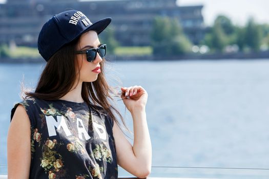 Street, outdoor. Attractive teen in a cap