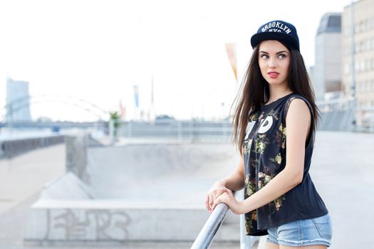 Street, outdoor. Attractive teen in a cap