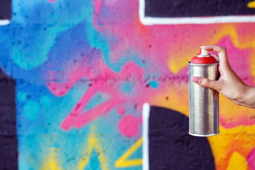 Vandalism, graffiti. Girl holding spray can