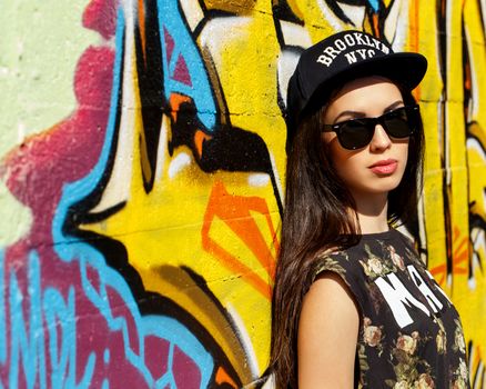 Street, outdoor. Attractive teen in a cap